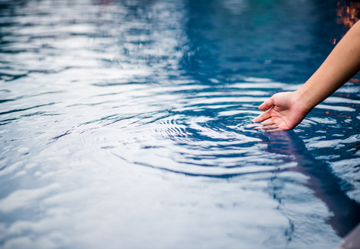 hand-that-touches-blue-water-pool-is-clean-bright-with-drop-water-o